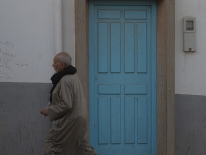 Against the backdrop of Tan-Tan's historic streets, locals stroll by leisurely, embodying the city's sense of community and neighborly camaraderie