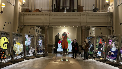 Mouna Rebeiz at the clear acrylic jigsaw totem featuring a poem from Baudelaire in Gothic calligraphy