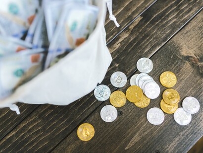 Foto de close-up de Bitcoins prateados e dourados em superfície de madeira