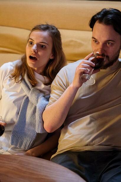 Man sips wine as wife watches tv in surprise