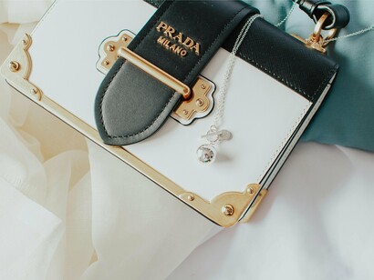 A luxury bag resting casually among elegant textures, symbolising the lived-in beauty of an iconic wardrobe