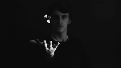 Mano lancia i dadi. Perché il caso ci è così ostico? A questa domanda non abbiamo ancora una risposta certa. Una delle ipotesi più accreditate è che la nostra incapacità di comprendere pienamente il caso derivi dalla tendenza a voler esercitare un controllo sull’ambiente che ci circonda