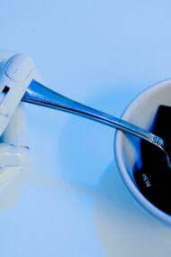 Mão biônica e mão humana apontando o dedo