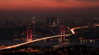 The Bosphorus Bridge comes alive with a mesmerizing glow as night falls over Istanbul