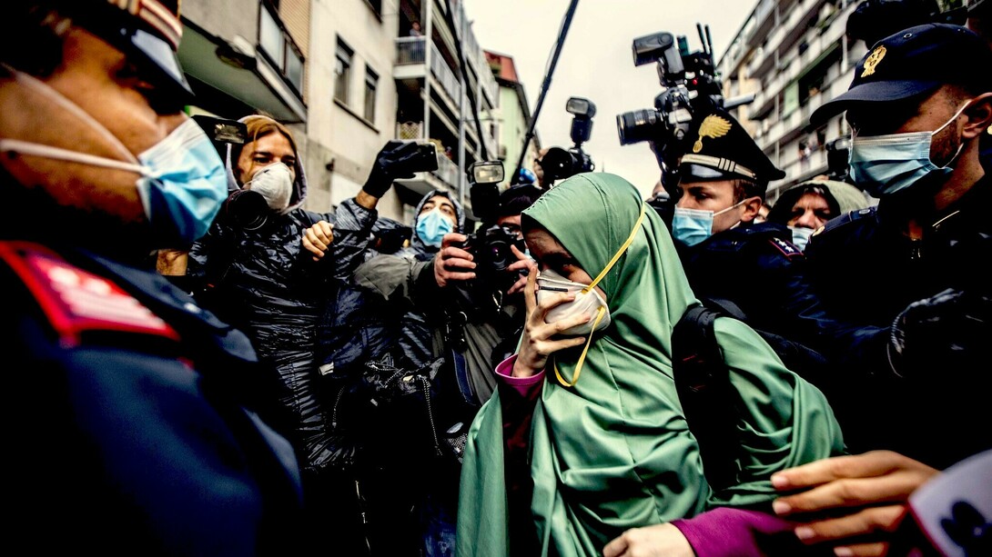 Silvia Romano en medio de una nube de periodistas, policías y curiosos