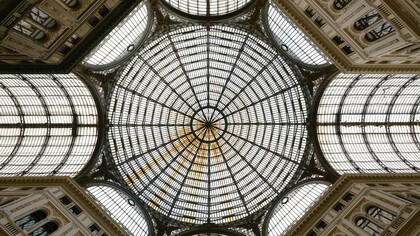 Nel centro storico di Napoli, l’intersezione tra l’eredità classica, le stratificazioni barocche e le pratiche informali genera un paesaggio urbano ibrido, dove la degeometria non cancella l’ordine, ma lo reinterpreta. Galleria Umberto I, Via Santa Brigida, Napoli, Italia