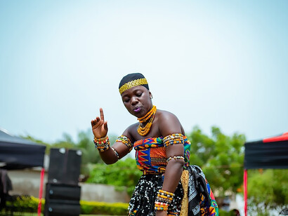 In the heart of Accra, Ghana, the spirit of cultural richness comes alive as a woman, elegantly dressed in traditional attire, engages in a captivating dance