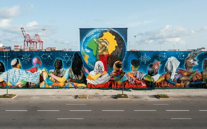 "Coexistence", de Eduardo Kobra, em Cotonou, na República do Benim em 2023. O mural reúne 12 figuras de costas, representando diferentes religiões, unidas diante de um globo que destaca a África e duas mãos entrelaçadas. Realizada na fachada do antigo Hotel do Porto, a obra ocupa cerca de 700 m² e transforma o espaço urbano em uma mensagem visual de tolerância, diálogo inter-religioso e convivência, reafirmando a presença internacional da arte urbana brasileira