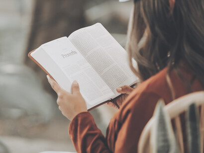 Mujer lee atentamente un libro sobre proverbios