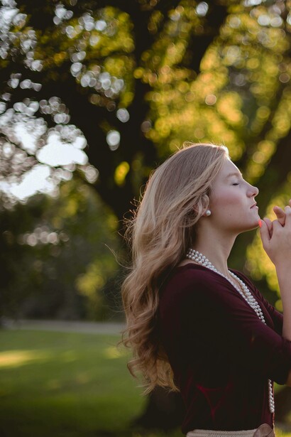 Woman saying a prayer in nature