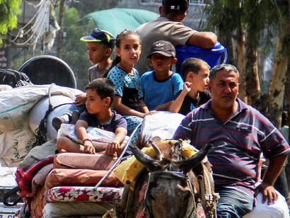 Children ride on a donkey-drawn cart, a poignant snapshot of life continuing in war zones despite immense hardship and destruction