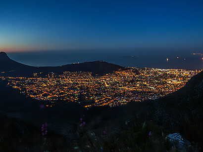 Dazzling nighttime cityscape of Cape Town, featuring iconic landmarks like Robben Island and Lion's Head, highlighting urbanization in South Africa