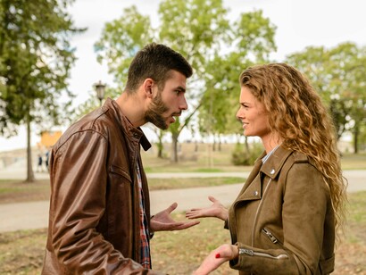 Um casal troca palavras em tom de desacordo em uma área ao ar livre. O desejo de vencer uma discussão raramente aproxima as pessoas