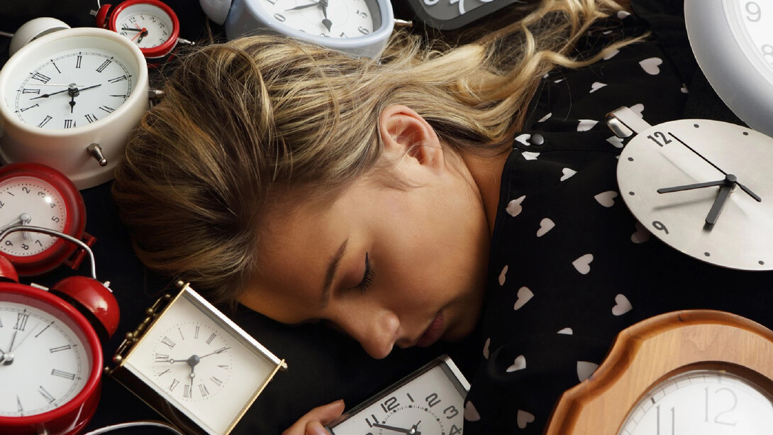 Mujer durmiendo entre relojes: a menudo, somos víctima de microdespertares sin saberlo, que arruinan literalmente nuestro descanso