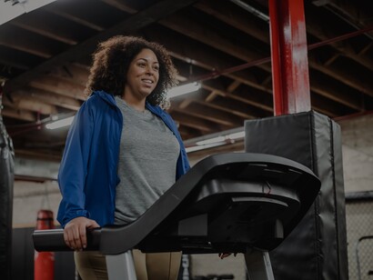 Mulher sorridente faz exercício na esteira