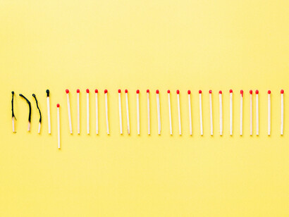 Charred matchsticks resting next to fresh ones, symbolising the unseen cost of burning too long without rest