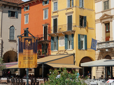 A lively street scene in Verona, Italy, surrounded by colorful historic buildings