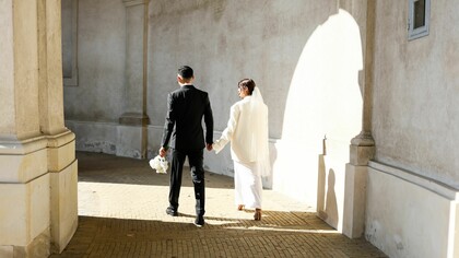 A newly married couple walking hand in hand into the light, representing the beginning of a lifelong partnership built on commitment