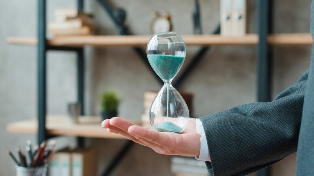 A businessman holding an hourglass in his office