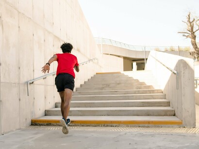 A man running up a stairs outdoors, reflecting the benefits of turning ordinary moments into fitness opportunities