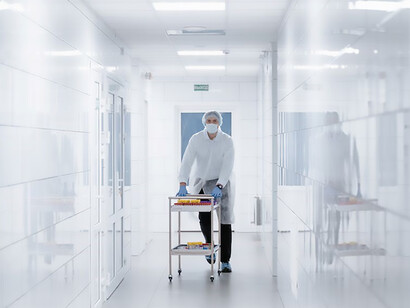A scientist, clad in a pristine white lab coat, strides purposefully down a gleaming corridor, embodying the pursuit of knowledge in a seamlessly sterile environment