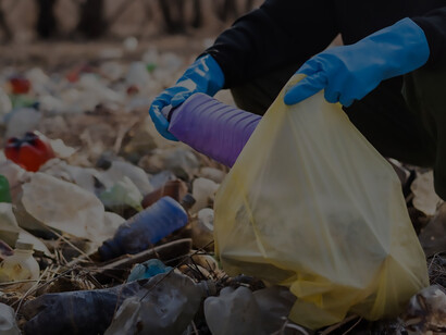 A man is committed to collecting stray plastic bottles from the ground, actively participating in recycling to address the issue of pollution