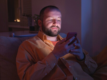 With every scroll, he reaches out into the void, but the silence of the room serves as a reminder of how far these connections fall short