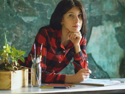 A woman drawing in her sketchpad