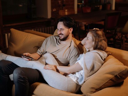 Couple laughing as they watch tv together