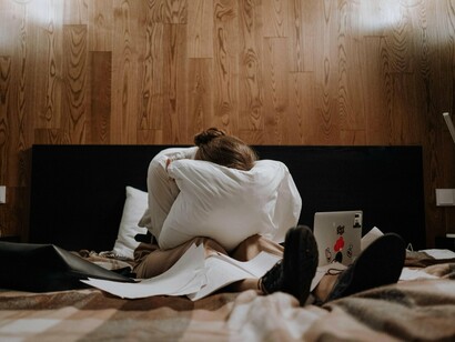A woman overwhelmed by exhaustion while surrounded by responsibilities, symbolising the unseen cost of chronic reproductive health conditions