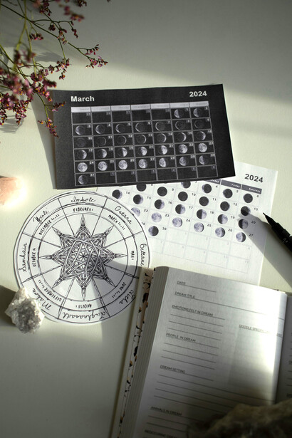 A minimalist workspace featuring a Wheel of the Year and calendar, reflecting the harmony between cosmic cycles and daily life