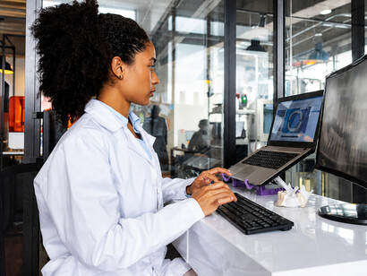 Healthcare professional designing a dental model in a 3D laboratory while using AI-powered medical software