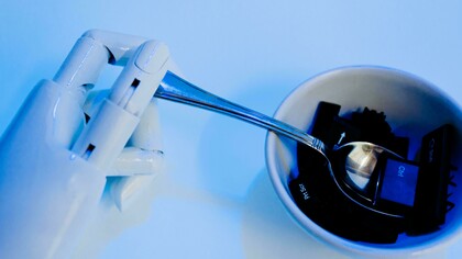 Mão biônica e mão humana apontando o dedo