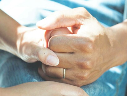 A patient holding tightly the hand of a loved one after discovering that they have co-infections