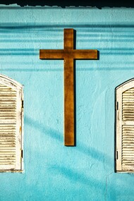 A wooden cross on a light blue wall