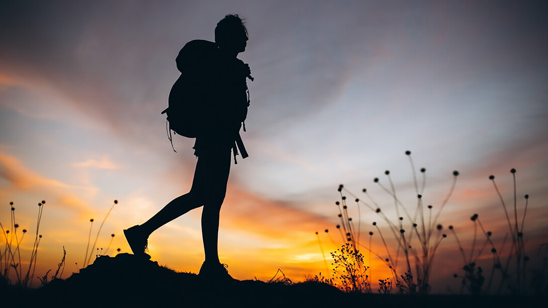 A woman rucking on the mountain during sunset