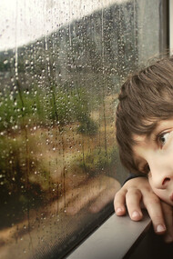 Niño mirando por la ventana