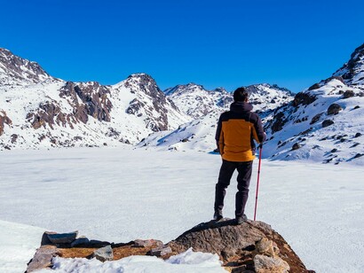 A man observing the frozen lake at Gosaikunda, Nepal