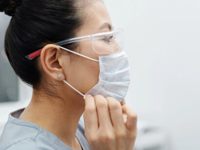 Donna indossa mascherina e occhiali per eseguire tampone naso faringeo durante la pandemia