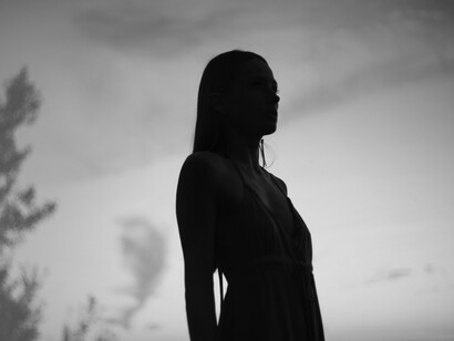 Silueta de mujer bajo un cielo nublado