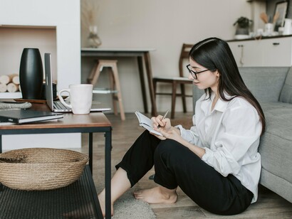 A writer sat on the floor working on their novel 
