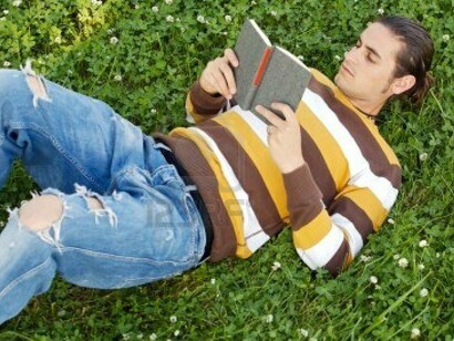 Un chico leyendo un libro en el parque