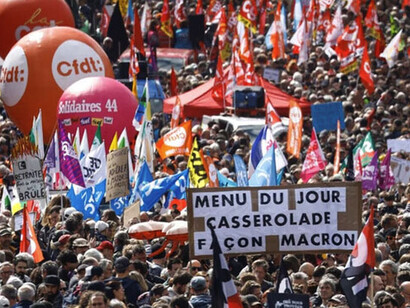 La gente asiste a la tradicional marcha del Primero de Mayo, un día de movilización contra la ley de reforma de las pensiones francesa y por la justicia social, en Nantes, Francia, el 1° de mayo. La pancarta dice "Menú del día: Cazuela a la Macron"