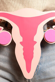 Front view woman holding woman reproductive system cardboard