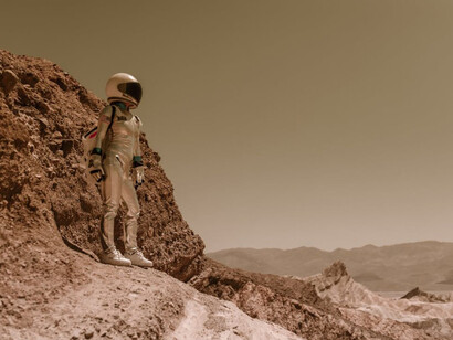 An astronaut standing on a rock on Mars, gazing at the vast Martian landscape