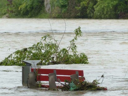 Una panchina di un parco quasi completamente sommersa dall'acqua alta durante un'alluvione