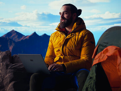 A man combining leisure and labour in a mountain setting, reflecting the new rhythm of flexible work culture