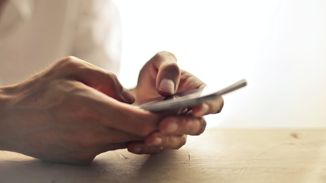 A person holding a mobile phone in their hands