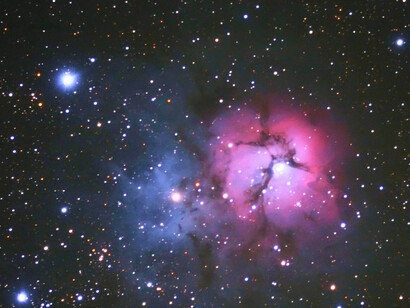 En la la nebulosa Trífida se pueden apreciar dos coloraciones diferenciadas: azuladas (por fuera) y rojizas (hacia el centro)