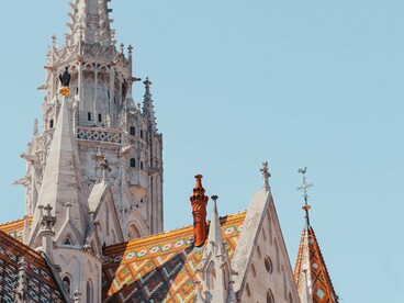 The colourful tiled roof and towering spire of Matthias Church in Budapest, Hungary, symbolising the value of integrity, stewardship, and genuine worship